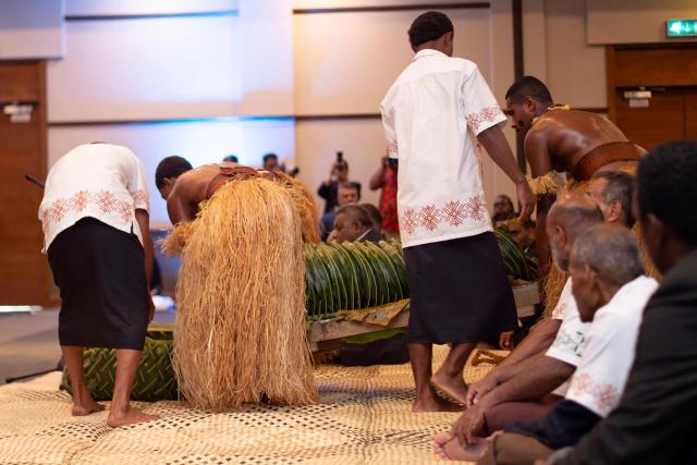 A pig wrapped in coconut leaves is presented to Australian Prime Minister Anthony Albanese during his greeting with Fiji's Prime Minister Sitiveni Rabuka at the Grand Pacific Hotel in Suva on July 6, 2026. Australia signed a new defence alliance with Fiji on July 6, bolstering ties with its South Pacific island neighbor as it seeks to outmanoeuvre China in the region. (Photo by LEON LORD / AFP)