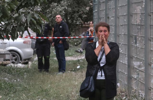 A local resident reacts as she looks at a residential building partially destroyed as a result of Russian missile strike on the Ukrainian capital of Kyiv on July 6, 2026, amid the Russian invasion in Ukraine. The death toll from Russian bombardment on the Kyiv region on July 6, has risen from eight to 10, authorities said, warning the number could rise further. (Photo by Serhii Okunev / AFP)
