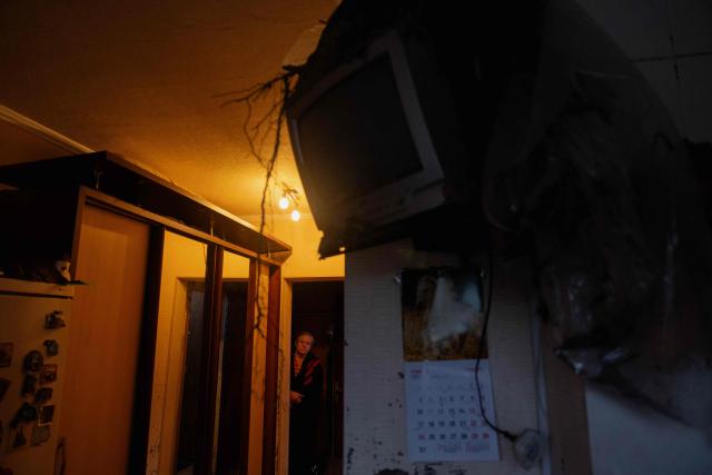 A woman stands near a television covered in debris following a Russian missile strike on the Ukrainian capital of Kyiv on July 6, 2026, amid the Russian invasion in Ukraine. The death toll from Russian bombardment on the Kyiv region on July 6, has risen from eight to 10, authorities said, warning the number could rise further. (Photo by Tetiana DZHAFAROVA / AFP)