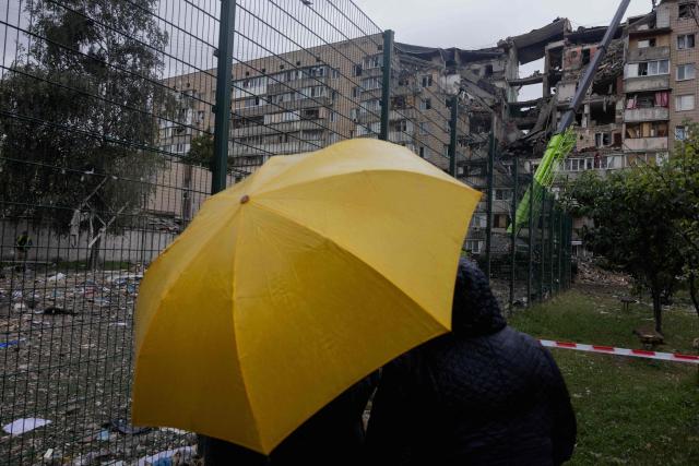 Local residents look at a damaged residential building following a Russian missile strike on the Ukrainian capital of Kyiv on July 6, 2026, amid the Russian invasion in Ukraine. The death toll from Russian bombardment on the Kyiv region on July 6, has risen from eight to 10, authorities said, warning the number could rise further. (Photo by Tetiana DZHAFAROVA / AFP)