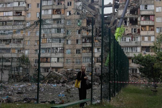 A girl looks at a damaged residential building following a Russian missile strike on the Ukrainian capital of Kyiv on July 6, 2026, amid the Russian invasion in Ukraine. The death toll from Russian bombardment on the Kyiv region on July 6, has risen from eight to 10, authorities said, warning the number could rise further. (Photo by Tetiana DZHAFAROVA / AFP)