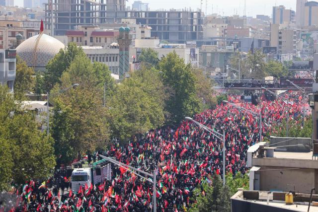 People gather along a street for the funeral procession of Iran's slain Supreme Leader Ali Khamenei in Tehran July 6, 2026. The funeral procession for Iran's late supreme leader Ali Khamenei began in Tehran on June 6, state television reported, as authorities prepared for crowds that could rival those that turned out for his predecessor nearly four decades ago. (Photo by AFP) / 