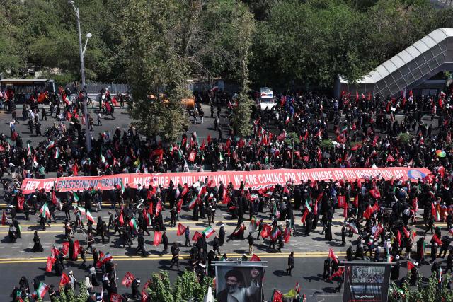 People gather along a street for the funeral procession of Iran's slain Supreme Leader Ali Khamenei in Tehran July 6, 2026. The funeral procession for Iran's late supreme leader Ali Khamenei began in Tehran on June 6, state television reported, as authorities prepared for crowds that could rival those that turned out for his predecessor nearly four decades ago. (Photo by AFP) / 