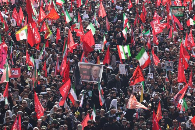 People hold a poster depicting US President Donald Trump and displaying the words "Revenge on Trump" while gathering along a street during the funeral procession of Iran's slain Supreme Leader Ali Khamenei in Tehran July 6, 2026. The funeral procession for Iran's late supreme leader Ali Khamenei began in Tehran on July 6, state television reported, as authorities prepared for crowds that could rival those that turned out for his predecessor nearly four decades ago. (Photo by ATTA KENARE / AFP) / 