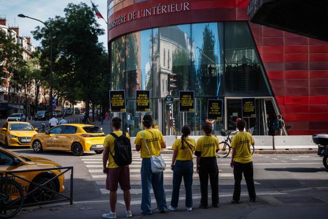Activists gather holding placards which read as 'No to Police's license to kill' and 'When the police kill, who is held accountable' during a symbolic action by Amnesty International against the criminal justice and victim respect bill at the Ministry of the Interior branch in Paris on July 6, 2026. The bill on the presumption of self-defense for law enforcement, which is due to be debated on July 7, 2026 at the National Assembly, risks creating a "license to kill" and a form of blanket immunity for police officers and gendarmes, human rights defenders warn. (Photo by Dimitar DILKOFF / AFP)