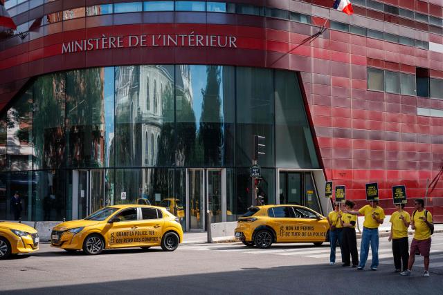 Activists gather holding placards which read as 'No to Police's license to kill' and 'When the police kill, who is held accountable' during a symbolic action by Amnesty International against the criminal justice and victim respect bill at the Ministry of the Interior branch in Paris on July 6, 2026. The bill on the presumption of self-defense for law enforcement, which is due to be debated on July 7, 2026 at the National Assembly, risks creating a "license to kill" and a form of blanket immunity for police officers and gendarmes, human rights defenders warn. (Photo by Dimitar DILKOFF / AFP)