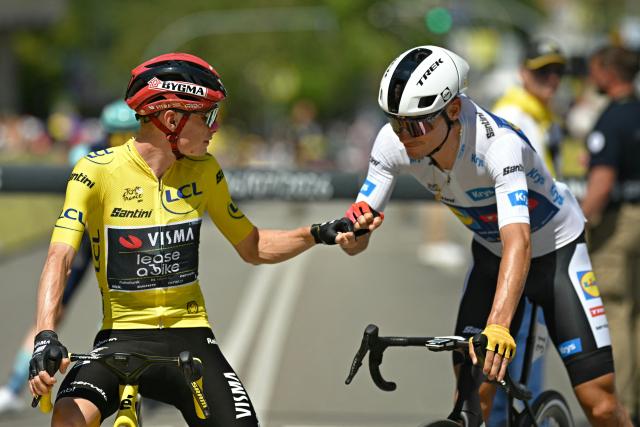 Team Visma | Lease a Bike's Danish rider Jonas Vingegaard wearing the overall leader's yellow jersey fist bumps Lidl - Trek team's Spanish rider Juan Ayuso wearing the best young rider's white jersey at the start of the 3rd stage of the 113th edition of the Tour de France cycling race, 196 km between Granollers and Les Angles in southern France, on July 6, 2026. (Photo by Loic VENANCE / AFP)