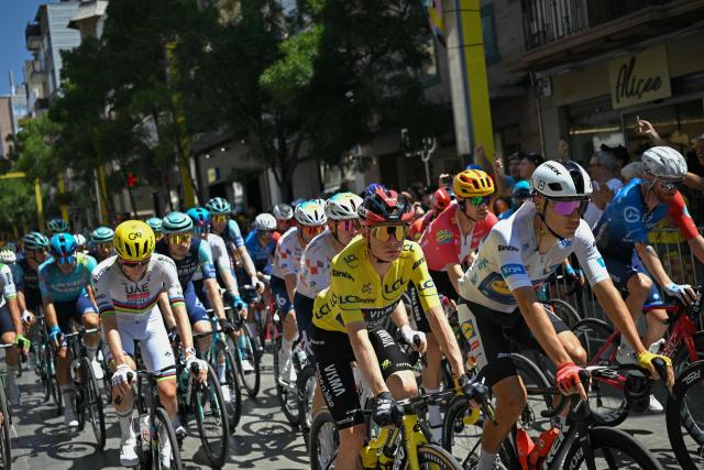 Team Visma | Lease a Bike's Danish rider Jonas Vingegaard wearing the overall leader's yellow jersey (C), Lidl - Trek team's Spanish rider Juan Ayuso wearing the best young rider's white jersey (R) and UAE Team Emirates - XRG's Slovenian rider Tadej Pogacar (L) cycle with the pack of riders (peloton) at the start of the 3rd stage of the 113th edition of the Tour de France cycling race, 196 km between Granollers and Les Angles in southern France, on July 6, 2026. (Photo by Loic VENANCE / AFP)