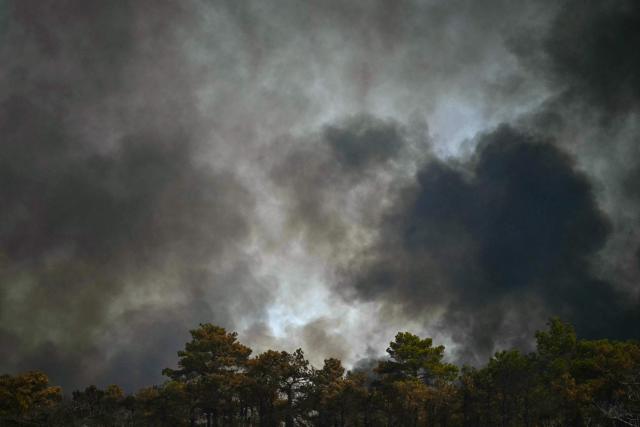 Smoke obscures the sky as a wildfire rages in the southern France department of Herault as 700 hundred firefighters backed by special aircraft battled to control a "gigantic" blaze in nearby department of Pyrenees-Orientales, near the town of Carlencas-et-Levas on July 6, 2026. Wildfires raged across southern Europe, forcing thousands of people to evacuate their homes and prompting officials to ban spectators from a stage of the storied Tour de France cycling race. (Photo by Gabriel BOUYS / AFP)