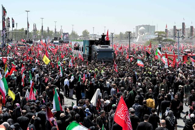 Mourners gather around the vehicle transporting the caskets of Iran's slain supreme leader Ali Khamenei and his family members during the funeral procession at Azadi Square in Tehran on July 6, 2026. Massive crowds are expected on July 6 for the funeral procession of late Iranian supreme leader Ali Khamenei in Tehran, with authorities hoping to avoid a repeat of the chaos that accompanied his predecessor's funeral. (Photo by Wakil Kohsar / AFP) / 