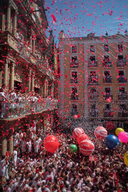 Revellers gather to celebrate during the "Chupinazo" (rocket launch) marking the official start of the San Fermin Festival in Plaza Consistorial outside the Town Hall of Pamplona in northern Spain on July 6, 2026. Thousands of people every year attend the week-long festival and its famous 'encierros' (bull runs) in which six bulls are released at 8:00 a.m. evey day starting July 7, to run from their corral to the bullring through the narrow streets of the old town over an 850 meters (yard) course while runners ahead of them try to stay close to the bulls without falling over or being gored. (Photo by JORGE GUERRERO / AFP)