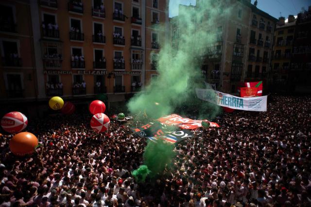 Revellers gather to celebrate during the "Chupinazo" (rocket launch) marking the official start of the San Fermin Festival in Plaza Consistorial outside the Town Hall of Pamplona in northern Spain on July 6, 2026. Thousands of people every year attend the week-long festival and its famous 'encierros' (bull runs) in which six bulls are released at 8:00 a.m. evey day starting July 7, to run from their corral to the bullring through the narrow streets of the old town over an 850 meters (yard) course while runners ahead of them try to stay close to the bulls without falling over or being gored. (Photo by JORGE GUERRERO / AFP)