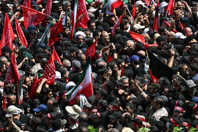 Mourners gather during the funeral procession of Iran's slain supreme leader Ali Khamenei and members of his family near Azadi Square in Tehran on July 6, 2026. Vast crowds gathered for the funeral procession of Khamenei in Tehran on July 6, with authorities estimating millions were on the streets in numbers that could rival those of his predecessor's farewell nearly four decades ago. (Photo by Ozan KOSE / AFP) / 
