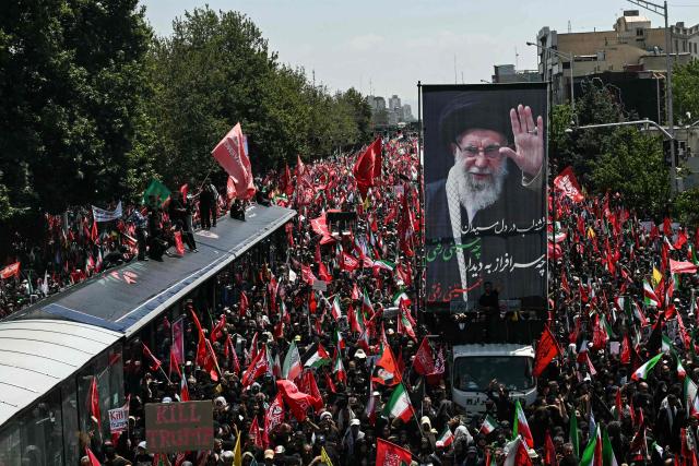 Mourners gather along the route of the convoy carrying the coffins of Iran's slain supreme leader Ali Khamenei and members of his family during a funeral procession in Tehran on July 6, 2026. Vast crowds gathered for the funeral procession of Khamenei in Tehran on July 6, with authorities estimating millions were on the streets in numbers that could rival those of his predecessor's farewell nearly four decades ago. (Photo by Ozan KOSE / AFP) / 