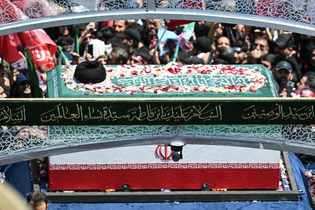 Crowds of mourners surround the convoy carrying the coffins of Iran's slain supreme leader Ali Khamenei and members of his family during a funeral procession near Azadi Square in Tehran on July 6, 2026. Vast crowds gathered for the funeral procession of Khamenei in Tehran on July 6, with authorities estimating millions were on the streets in numbers that could rival those of his predecessor's farewell nearly four decades ago. (Photo by Ozan KOSE / AFP) / 