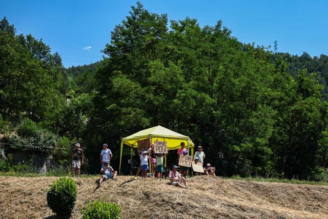 Spectators shelters from the afternoon sun along the race route during the 3rd stage of the 113th edition of the Tour de France cycling race, 195,9 km between Granollers in Spain and Les Angles in southern France, on July 6, 2026. (Photo by Anne-Christine POUJOULAT / AFP)