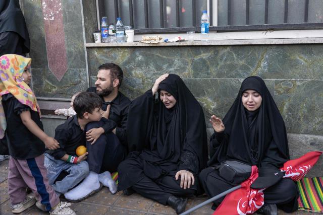 Mourners react as they attend the funeral procession of Iran's slain supreme leader Ali Khamenei and his family members, along a street in Tehran July 6, 2026. Vast crowds gathered for the funeral procession of Iran's slain supreme leader Ali Khamenei in Tehran on July 6, with authorities estimating millions were on the streets in numbers that could rival those of his predecessor's farewell nearly four decades ago. (Photo by AFP) / 