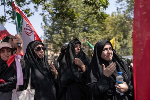 Mourners react as they attend the funeral procession of Iran's slain supreme leader Ali Khamenei and his family members, along a street in Tehran July 6, 2026. Vast crowds gathered for the funeral procession of Iran's slain supreme leader Ali Khamenei in Tehran on July 6, with authorities estimating millions were on the streets in numbers that could rival those of his predecessor's farewell nearly four decades ago. (Photo by AFP) / 