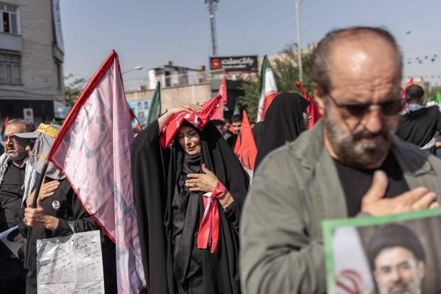Mourners react as they attend the funeral procession of Iran's slain supreme leader Ali Khamenei and his family members, along a street in Tehran July 6, 2026. Vast crowds gathered for the funeral procession of Iran's slain supreme leader Ali Khamenei in Tehran on July 6, with authorities estimating millions were on the streets in numbers that could rival those of his predecessor's farewell nearly four decades ago. (Photo by AFP) / 