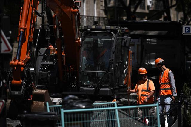 Construction workers take a break as they work on a road levelling site in Bordeaux, south-western France on July 6, 2026, as France experiences another heatwave. (Photo by Christophe ARCHAMBAULT / AFP)