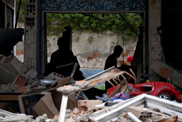 Residents search through belongings in a damaged apartment inside a partially collapsed building in Caraballeda, La Guaira state, Venezuela, on July 6, 2026, following earthquakes that struck the region. The earthquakes that struck Venezuela on June 24 have claimed the lives of at least 3,342 people, the Venezuelan government reported on July 5. (Photo by Juan BARRETO / AFP)