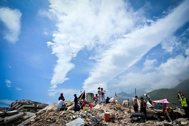 Resindents wait for assistance to recover the bodies of their loved ones before heavy machinery removes debris in the Caribe sector of Caraballeda, La Guaira state, Venezuela, on July 6, 2026, following earthquakes that struck the region. The earthquakes that struck Venezuela on June 24 have claimed the lives of at least 3,342 people, the Venezuelan government reported on July 5. (Photo by MARTIN BERNETTI / AFP)