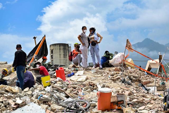 Resindents wait for assistance to recover the bodies of their loved ones before heavy machinery removes debris in the Caribe sector of Caraballeda, La Guaira state, Venezuela, on July 6, 2026, following earthquakes that struck the region. The earthquakes that struck Venezuela on June 24 have claimed the lives of at least 3,342 people, the Venezuelan government reported on July 5. (Photo by MARTIN BERNETTI / AFP)
