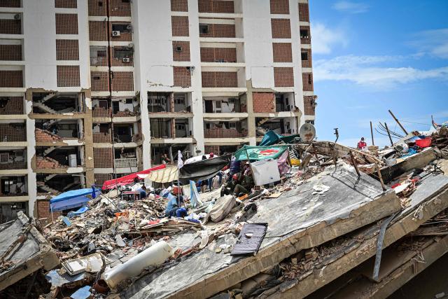 Residents shelter in makeshift tents erected atop the rubble of their collapsed buildings in the Caribe sector of Caraballeda, La Guaira state, Venezuela, on July 6, 2026, as they seek to prevent heavy machinery from entering the site before the bodies of their loved ones are recovered following the June 24 earthquakes. The earthquakes that struck Venezuela on June 24 have claimed the lives of at least 3,342 people, the Venezuelan government reported on July 5. (Photo by MARTIN BERNETTI / AFP)