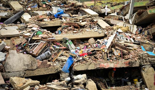 A resident removes belongings from a destroyed building in the Caribe sector of Caraballeda, La Guaira state, Venezuela, on July 6, 2026, following earthquakes that struck the region. The earthquakes that struck Venezuela on June 24 have claimed the lives of at least 3,342 people, the Venezuelan government reported on July 5. (Photo by MARTIN BERNETTI / AFP)