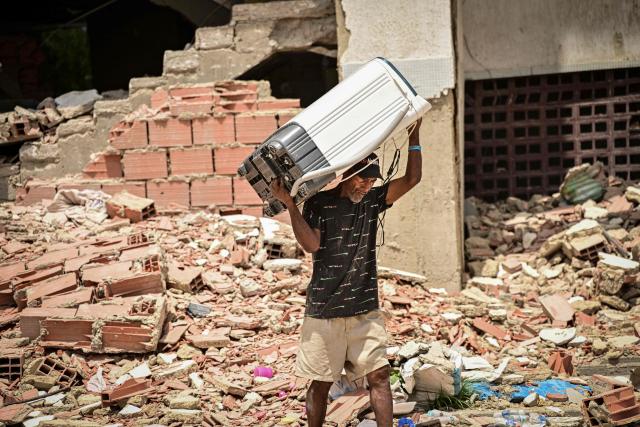 A resident removes belongings from a destroyed building in the Caribe sector of Caraballeda, La Guaira state, Venezuela, on July 6, 2026, following earthquakes that struck the region. The earthquakes that struck Venezuela on June 24 have claimed the lives of at least 3,342 people, the Venezuelan government reported on July 5. (Photo by MARTIN BERNETTI / AFP)
