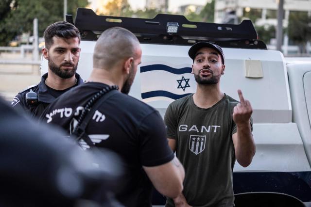 An Israeli right-wing activist gestures towards left-wing activists (not pictured) in Tel Aviv on July 6, 2026, during a rally calling for release of Palestinian Gaza Doctor Hussan Abu Safiya, detained by Israeli forces since December 2024. Last month, Israel's Supreme Court struck down a government ban preventing International Committee of the Red Cross (ICRC) delegates from visiting Palestinian detainees in Israeli prisons, prompting calls on June 4 to resume such visits. (Photo by ilia YEFIMOVICH / AFP)