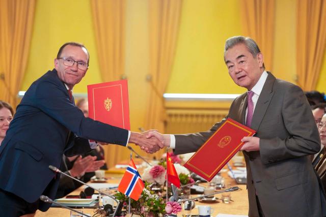 Chinese Foreign Minister Wang Yi (R) shakes hands with Norwegian Foreign Minister Espen Barth Eide after they signed documents during a meeting at the Prime Minister's Residence in Oslo, Norway on July 6, 2026. (Photo by Javad Parsa / NTB / AFP) / Norway OUT