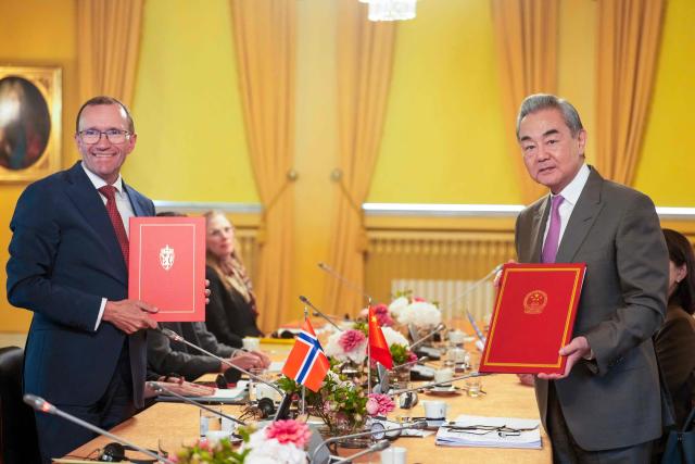 Chinese Foreign Minister Wang Yi (R) and Norwegian Foreign Minister Espen Barth Eide pose after they signed documents during a meeting at the Prime Minister's Residence in Oslo, Norway on July 6, 2026. (Photo by Javad Parsa / NTB / AFP) / Norway OUT