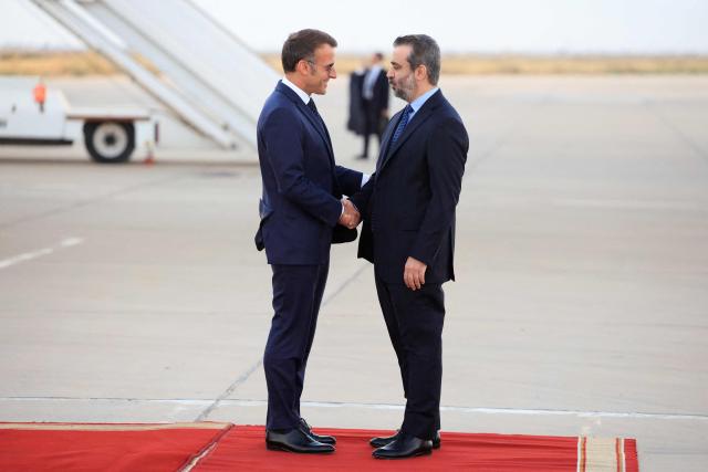 France's President Emmanuel Macron (L) is welcomed by Syria's Foreign Minister Asaad al-Shaibani (R) as he arrives for a state visit at the Damascus International Airport in Damascus on July 6, 2026. French President Emmanuel Macron arrived in Damascus on July 6, 2026 for the first visit by a Western European head of state since Syria's new authorities took power in 2024, an AFP journalist said. Macron, who will depart on July 7, 2026, will advocate for "a free, pluralist Syria that respects each of its components" and plays a role in moderating Middle East tensions, the French presidency told journalists ahead of his arrival. (Photo by Ludovic MARIN / AFP)