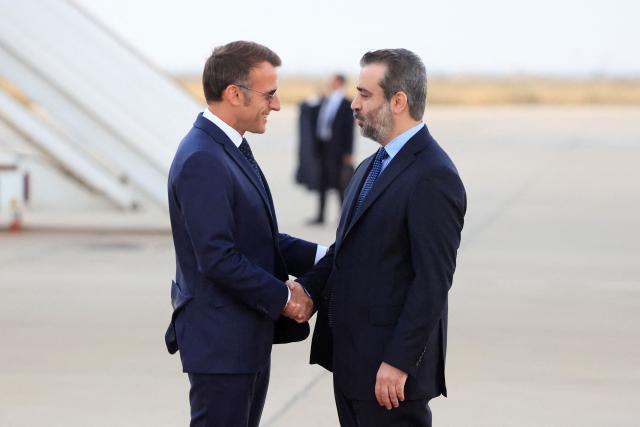 France's President Emmanuel Macron (L) is welcomed by Syria's Foreign Minister Asaad al-Shaibani (R) as he arrives for a state visit at the Damascus International Airport in Damascus on July 6, 2026. French President Emmanuel Macron arrived in Damascus on July 6, 2026 for the first visit by a Western European head of state since Syria's new authorities took power in 2024, an AFP journalist said. Macron, who will depart on July 7, 2026, will advocate for "a free, pluralist Syria that respects each of its components" and plays a role in moderating Middle East tensions, the French presidency told journalists ahead of his arrival. (Photo by Ludovic MARIN / AFP)