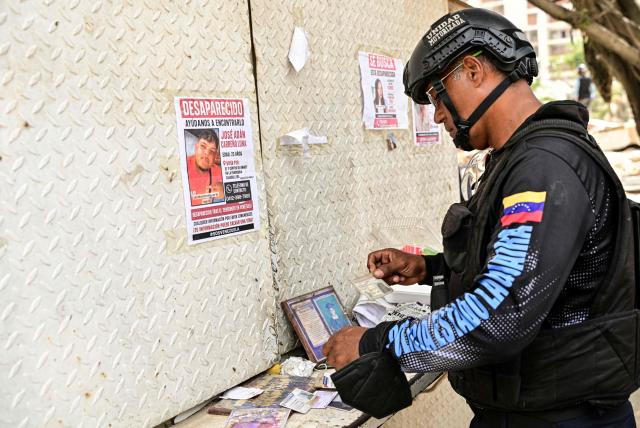 A police officer arranges several identity cards found in the rubble of collapsed buildings belonging to missing persons in the Caribe sector of Caraballeda, La Guaira state, Venezuela, on July 6, 2026, following powerful earthquakes that struck the region. The earthquakes that struck Venezuela on June 24 have claimed the lives of at least 3,342 people, the Venezuelan government reported on July 5. (Photo by MARTIN BERNETTI / AFP)