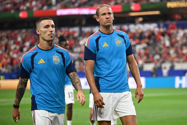 Spain's defender #03 Alex Grimaldo and midfielder #05 Marcos Llorente walk on the pitch during warm up ahead of the 2026 World Cup round of 16 football match between Portugal and Spain at the Dallas Stadium in Arlington on July 6, 2026. (Photo by Paul ELLIS / AFP)