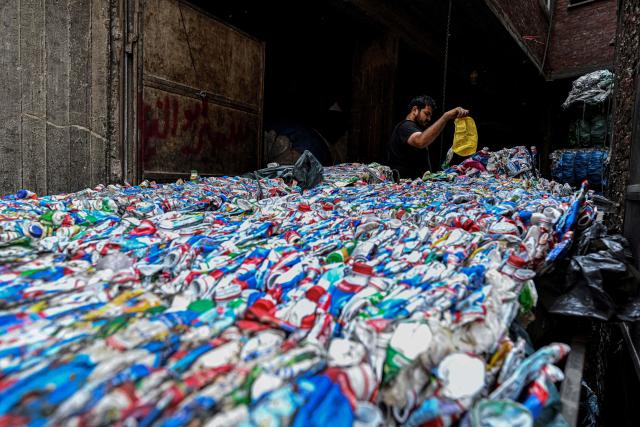 An Egyptian worker prepares plastic for processing at a recycling plant at the garbage city in the Manshiyet Nasser neighbourhood in Cairo on July 6, 2026. (Photo by Khaled DESOUKI / AFP)