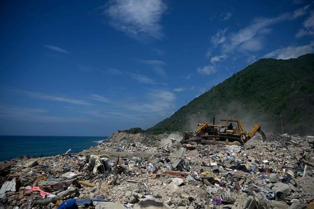 Heavy machinery clears debris from collapsed buildings in Caraballeda, La Guaira state, Venezuela, on July 6, 2026, following powerful earthquakes that struck the regio. The earthquakes that struck Venezuela on June 24 have claimed the lives of at least 3,342 people, the Venezuelan government reported on July 5. (Photo by Federico PARRA / AFP)