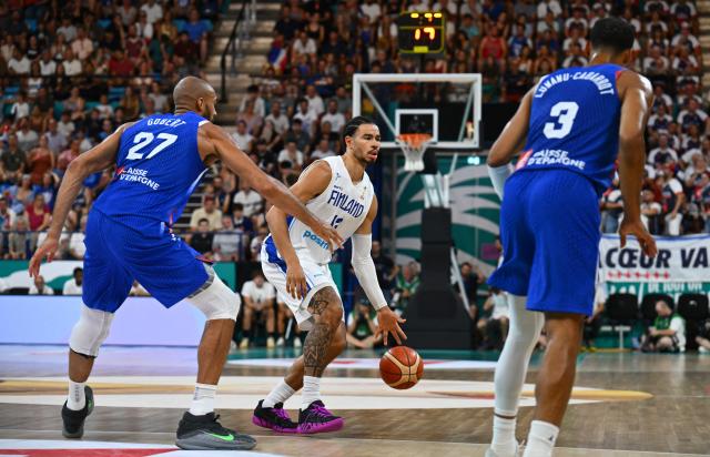 Finland's #13 Olivier Nkamhoua (C) dribbles to pass France's #27 Rudy Gobert (L) during the qualifier basketball match between France and Finland for the men's 2027 FIBA World Championships at the Palais des Sports in Pau, south-western France on July 6, 2026. (Photo by Gaizka IROZ / AFP)