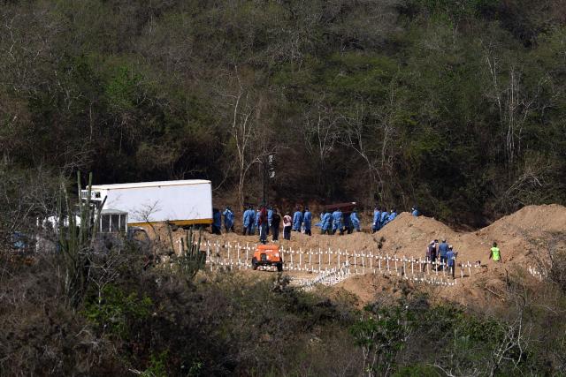 Workers prepare graves for victims of the June 24 earthquake at La Esperanza Cemetery in Carayaca, La Guaira state, northeast of Caracas, on July 5, 2026. The twin earthquakes that struck Venezuela on June 24 have claimed the lives of at least 3,535 people, the Venezuelan government reported on July 5. (Photo by Lucas AGUAYO / AFP)