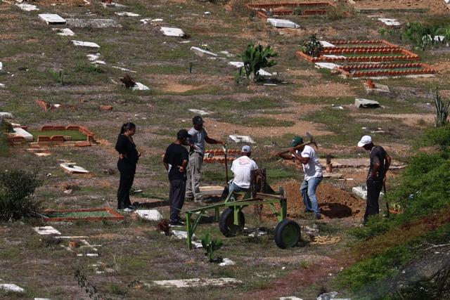 Workers prepare graves for victims of the June 24 earthquake at La Esperanza Cemetery in Carayaca, La Guaira state, northeast of Caracas, on July 5, 2026. The twin earthquakes that struck Venezuela on June 24 have claimed the lives of at least 3,535 people, the Venezuelan government reported on July 5. (Photo by Lucas AGUAYO / AFP)