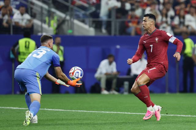 Spain's goalkeeper #23 Unai Simon grabs the ball past Portugal's forward #07 Cristiano Ronaldo during the 2026 World Cup round of 16 football match between Portugal and Spain at the Dallas Stadium in Arlington on July 6, 2026. (Photo by Aric Becker / AFP)