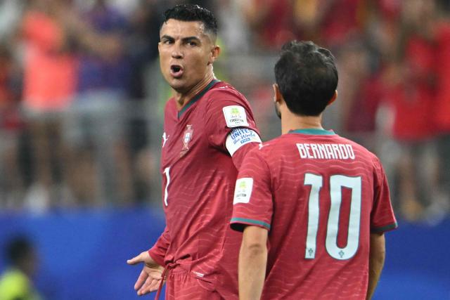 Portugal's forward #07 Cristiano Ronaldo talks to his teammate midfielder #10 Bernardo Silva after their team conceded Spain's first goal during the 2026 World Cup round of 16 football match between Portugal and Spain at the Dallas Stadium in Arlington on July 6, 2026. (Photo by RONALDO SCHEMIDT / AFP)