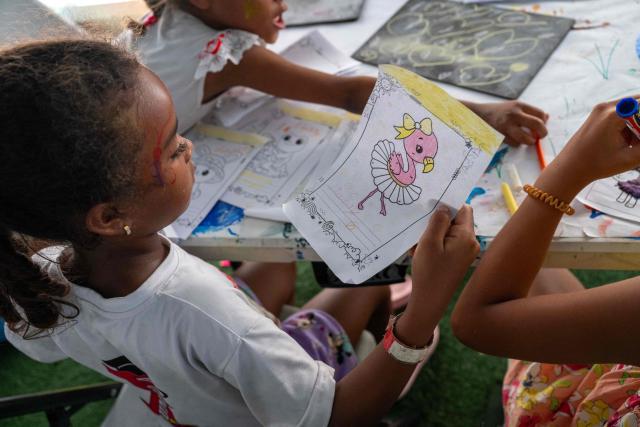 Children displaced by the June 24 earthquake colour drawings at a temporary shelter set up at the Jose Maria Vargas sports complex in Catia la Mar, La Guaira state, Venezuela, on July 6, 2026. The twin earthquakes that struck Venezuela on June 24 have claimed the lives of at least 3,535 people, the Venezuelan government reported on July 5. (Photo by Miguel MEDINA / AFP)