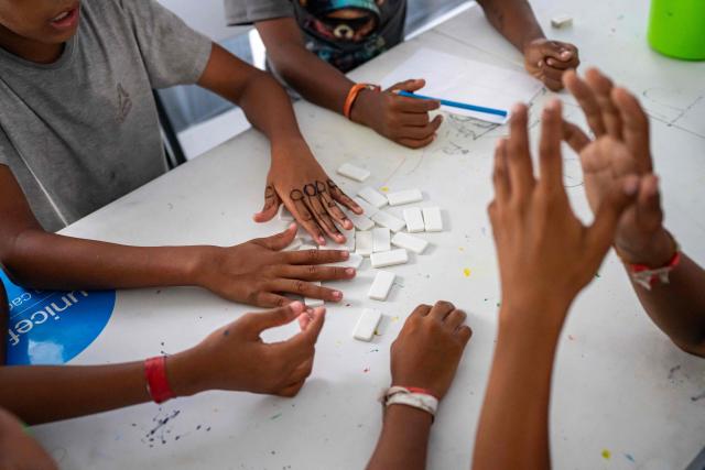 Children displaced by the June 24 earthquake play dominoes at a temporary shelter set up at the Jose Maria Vargas sports complex in Catia la Mar, La Guaira state, Venezuela, on July 6, 2026. The twin earthquakes that struck Venezuela on June 24 have claimed the lives of at least 3,535 people, the Venezuelan government reported on July 5. (Photo by Miguel MEDINA / AFP)