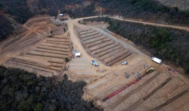 This aerial view shows plots containing the coffins of victims of the June 24 earthquakes, at La Esperanza Cemetery in Carayaca, La Guaira state, northeast of Caracas, on July 6, 2026. Up to now, the twin earthquakes that struck Venezuela have claimed the lives of 3,535 people, the Venezuelan government reported. (Photo by Miguel MEDINA / AFP)