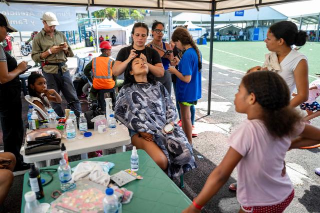 A displaced woman receives a beauty treatment at a temporary shelter set up at the Jose Maria Vargas sports complex in Catia la Mar, La Guaira state, Venezuela, on July 6, 2026, following the June 24 earthquakes. The twin earthquakes that struck Venezuela on June 24 have claimed the lives of at least 3,535 people, the Venezuelan government reported on July 5. (Photo by Miguel MEDINA / AFP)