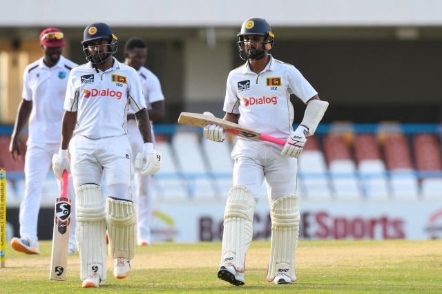 Kamindu Mendis (L) and Dinesh Chandimal (R) of Sri Lanka walk off the field at the end of the 4th day of the 2nd Test between Sri Lanka and West Indies at Vivian Richards Cricket Stadium in North Sound, Antigua and Barbuda, on July 6, 2026. (Photo by Randy Brooks / AFP)
