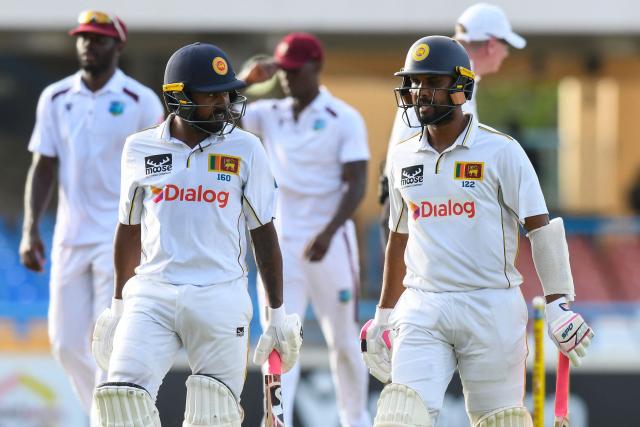 Kamindu Mendis (L) and Dinesh Chandimal (R) of Sri Lanka walk off the field at the end of the 4th day of the 2nd Test between Sri Lanka and West Indies at Vivian Richards Cricket Stadium in North Sound, Antigua and Barbuda, on July 6, 2026. (Photo by Randy Brooks / AFP)